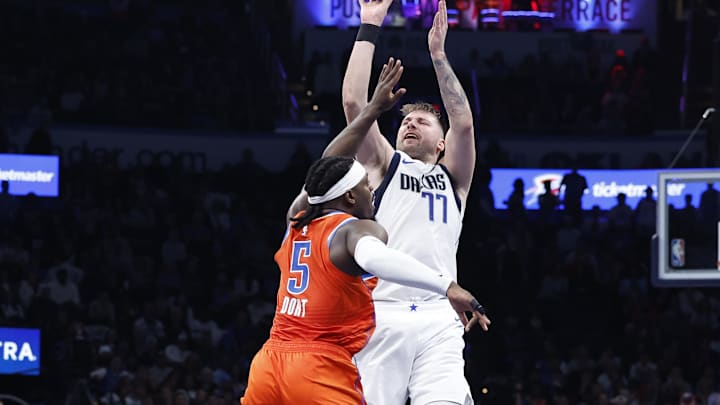 Dec 10, 2024; Oklahoma City, Oklahoma, USA; Dallas Mavericks guard Luka Doncic (77) shoots over Oklahoma City Thunder guard Luguentz Dort (5) during the second half at Paycom Center. Mandatory Credit: Alonzo Adams-Imagn Images
