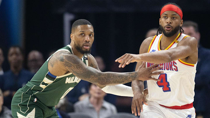 Mar 18, 2025; San Francisco, California, USA: Golden State Warriors guard Moses Moody (4) passes away from defensive pressure by Milwaukee Bucks guard Damian Lillard (0) during the first quarter at Chase Center. Mandatory Credit: D. Ross Cameron-Imagn Images