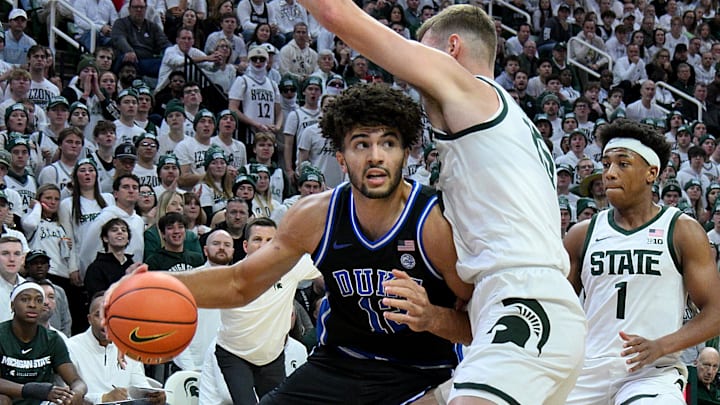 Dec 6, 2025; East Lansing, Michigan, USA;  Duke Blue Devils forward Cameron Boozer (12) advances against Michigan State Spartans center Carson Cooper (15) during the first half at Jack Breslin Student Events Center. Mandatory Credit: Dale Young-Imagn Images