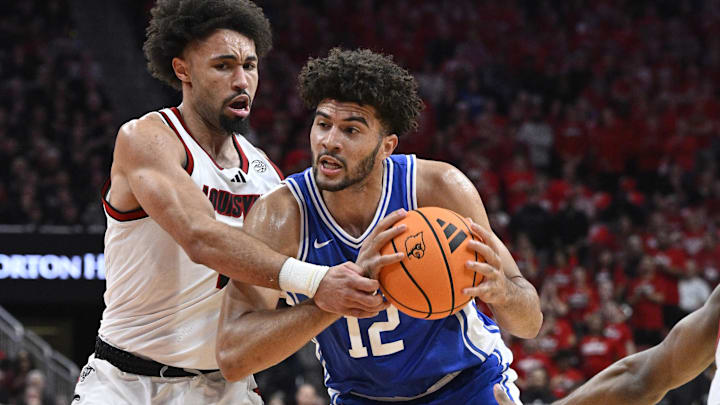 Jan 6, 2026; Louisville, Kentucky, USA; Duke Blue Devils forward Cameron Boozer (12) drives to the basket against Louisville Cardinals guard J'vonne Hadley (1) during the first half at KFC Yum! Center. Mandatory Credit: Jamie Rhodes-Imagn Images Jan 6, 2026; Louisville, Kentucky, USA; Duke Blue Devils forward Cameron Boozer (12) drives to the basket against Louisville Cardinals guard J'vonne Hadley (1) during the first half at KFC Yum! Center. Mandatory Credit: Jamie Rhodes-Imagn Images
