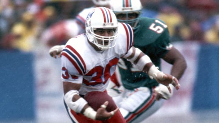 Sep 18, 1987; Foxboro, MA, USA; FILE PHOTO; New England Patriots running back Mosi Tatupu (30) carries the ball against the Miami Dolphins at Foxboro Stadium. Mandatory Credit: Dick Raphael-Imagn Images