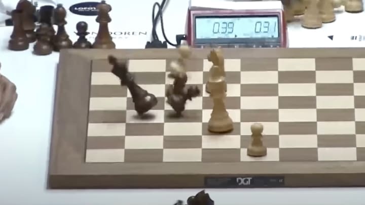 Chess pieces go flying as Magnus Carlsen hits the table in the final seconds of a match against Gukesh Dommaraju.