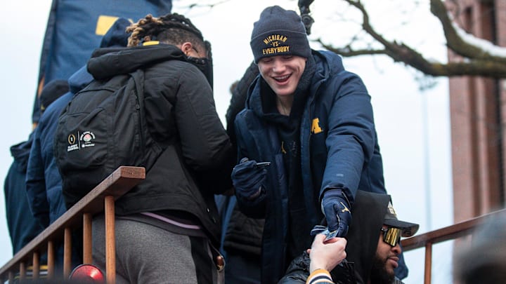 Michigan quarterback J.J. McCarthy signs autographs for fans during the National Championship parade