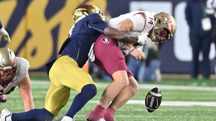 Nov 9, 2024; South Bend, Indiana, USA; Florida State Seminoles quarterback Luke Kromenhoek (14) is sacked by Notre Dame Fighting Irish linebacker Jaylen Sneed (3) in the third quarter at Notre Dame Stadium. Mandatory Credit: Matt Cashore-Imagn Images