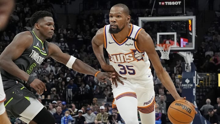 Mar 28, 2025; Minneapolis, Minnesota, USA; Phoenix Suns forward Kevin Durant (35) brings the ball up as Minnesota Timberwolves guard Anthony Edwards (5) defends him in the fourth quarter at Target Center.