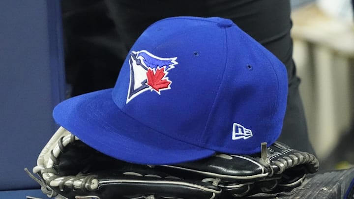 Apr 27, 2024; Toronto, Ontario, CAN; A Toronto Blue Jays hat and glove in the dugout during the third inning against the Los Angeles Dodgers at Rogers Centre. Mandatory Credit: John E. Sokolowski-Imagn Images