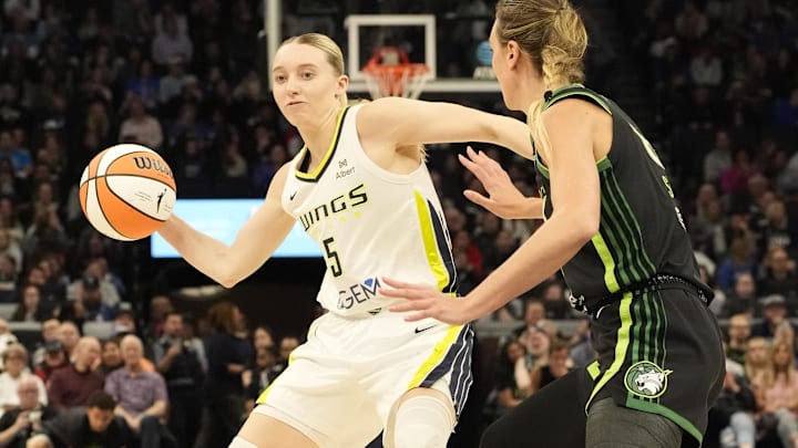 May 21, 2025; Minneapolis, Minnesota, USA; Dallas Wings guard Paige Bueckers (5) passes against Minnesota Lynx forward Alanna Smith (8) in the second quarter at Target Center. Mandatory Credit: Bruce Kluckhohn-Imagn Images