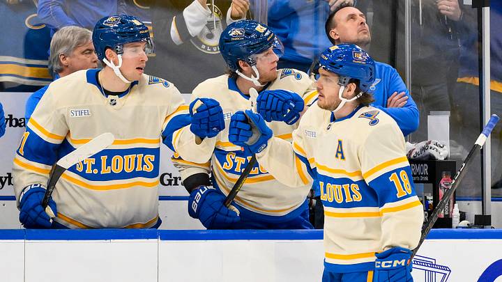 Feb 8, 2025; St. Louis, Missouri, USA;  St. Louis Blues center Robert Thomas (18) is congratulated by left wing Jake Neighbours (63) and center Dylan Holloway (81) after scoring the game tying goal against the Chicago Blackhawks during the third period at Enterprise Center. Mandatory Credit: Jeff Curry-Imagn Images