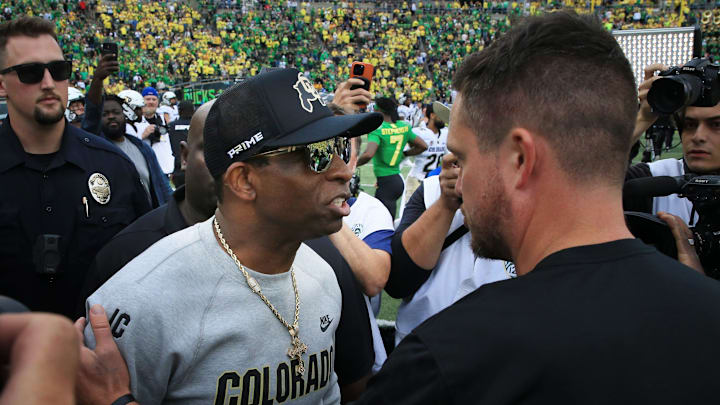 Colorado coach Deion Sanders, left, and Oregon's Dan Lanning meet at midfield after the game at Autzen Stadium.