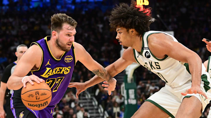 Mar 13, 2025; Milwaukee, Wisconsin, USA;  Los Angeles Lakers guard Luka Doncic (77) drives to the basket against Milwaukee Bucks center Jericho Sims (00) in the fourth quarter at Fiserv Forum. Mandatory Credit: Benny Sieu-Imagn Images