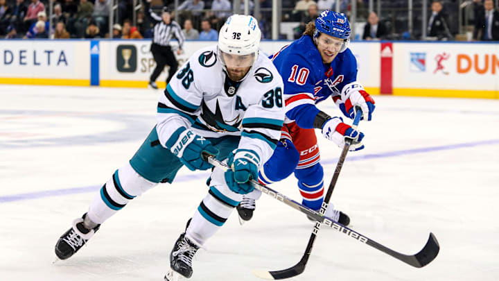 Oct 20, 2022; New York, New York, USA; San Jose Sharks defenseman Mario Ferraro (38) and New York Rangers left wing Artemi Panarin (10) fight for the puck during the third period at Madison Square Garden. Mandatory Credit: Danny Wild-Imagn Images