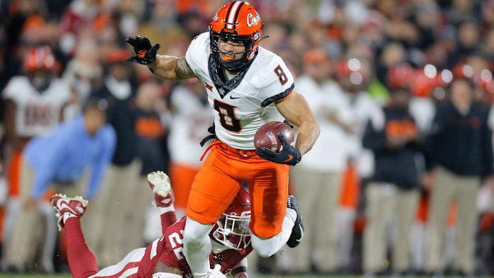 Oklahoma State's Braydon Johnson (8) is brought down by Oklahoma's C.J. Coldon (22) during a Bedlam