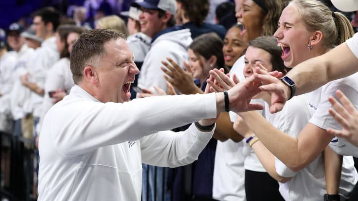 Penn State men's basketball coach Mike Rhoades high-fives Penn State students following a victory over Ohio State at the Bryce Jordan Center.