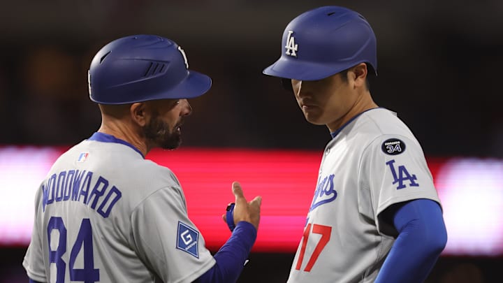Apr 4, 2025; Philadelphia, Pennsylvania, USA; Los Angeles Dodgers designated hitter Shohei Ohtani (17) talks with first base coach/infield coach Chris Woodward (84) during the eighth inning inning against the Philadelphia Phillies at Citizens Bank Park. Mandatory Credit: Bill Streicher-Imagn Images