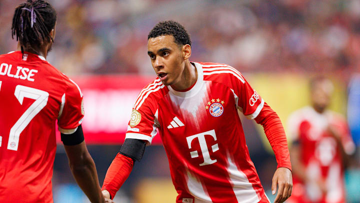 Jamal Musiala klatscht mit Teamkollege Olise ab