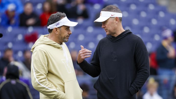 Nov 2, 2024; Seattle, Washington, USA; Washington Huskies head coach Jedd Fisch, left, talks with USC Trojans head coach Lincoln Riley during pregame warmups at Alaska Airlines Field at Husky Stadium. Mandatory Credit: Joe Nicholson-Imagn Images