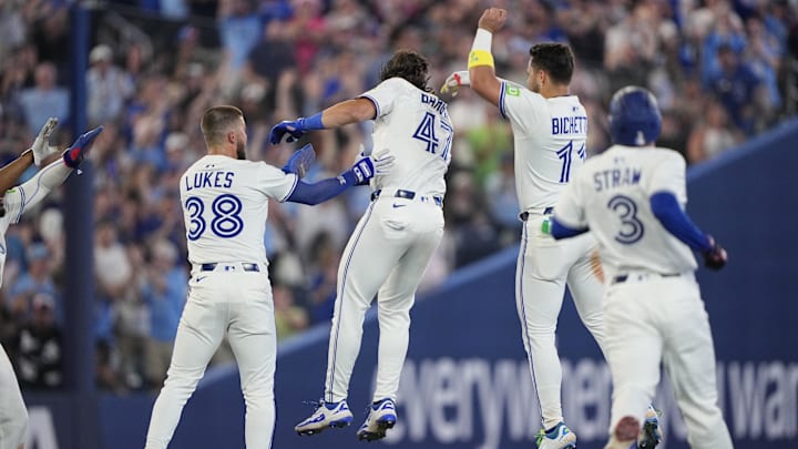 Jul 5, 2025; Toronto, Ontario, CAN; Toronto Blue Jays center fielder Nathan Lukes (38) and shortstop Bo Bichette (11) congratulate right fielder Addison Barger (47) after his walk off single against the Los Angeles Angels during the 11th inning at Rogers Centre. 