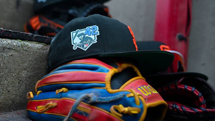 Apr 15, 2026; Cincinnati, Ohio, USA;  The Jackie Robinson patch is seen on a San Francisco Giants game hat, resting on the dugout steps, during the game against the Cincinnati Reds in the first inning at Great American Ball Park. Players and coaches will wear No. 42 in honor of Jackie Robinson Day around the league. Mandatory Credit: Aaron Doster-Imagn Images