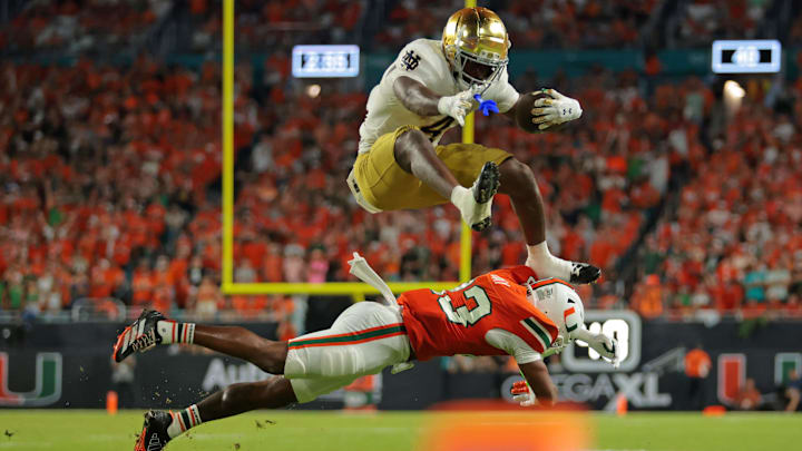Notre Dame Fighting Irish running back Jeremiyah Love (4) hurdles over Miami Hurricanes defensive back Dylan Day (23) at Hard Rock Stadium. Notre Dame Fighting Irish running back Jeremiyah Love (4) hurdles over Miami Hurricanes defensive back Dylan Day (23) at Hard Rock Stadium.