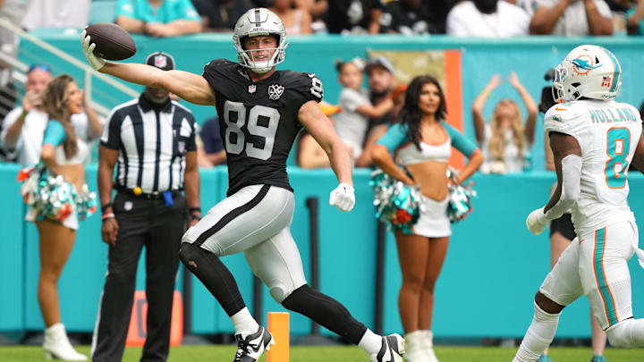 Nov 17, 2024; Miami Gardens, Florida, USA; Las Vegas Raiders tight end Brock Bowers (89) scores a touchdown past Miami Dolphins safety Jevon Holland (8) in the third quarter at Hard Rock Stadium. Mandatory Credit: Jim Rassol-Imagn Images
