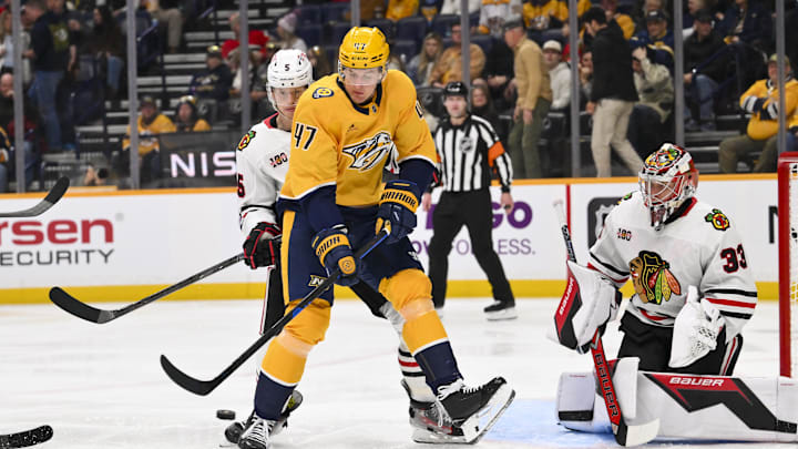 Jan 10, 2026; Nashville, Tennessee, USA;  Chicago Blackhawks goaltender Drew Commesso (33) blocks the shot of Nashville Predators right wing Michael McCarron (47) during the third period at Bridgestone Arena. Mandatory Credit: Steve Roberts-Imagn Images