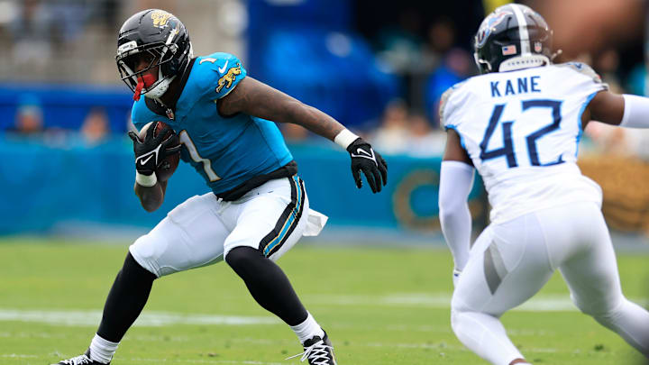 Jacksonville Jaguars running back Travis Etienne Jr. (1) jukes against Tennessee Titans safety Sanoussi Kane (42) during the first quarter of an NFL football matchup at EverBank Stadium, Sunday, Jan. 4, 2026, in Jacksonville, Fla. The Jaguars defeated the Titans 41-7, capturing the AFC South title. [Corey Perrine/Florida Times-Union]