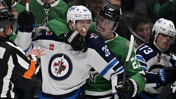 Apr 10, 2025; Dallas, Texas, USA; Dallas Stars left wing Mason Marchment (27) holds back Winnipeg Jets center Morgan Barron (36) during the first period at the American Airlines Center. Mandatory Credit: Jerome Miron-Imagn Images