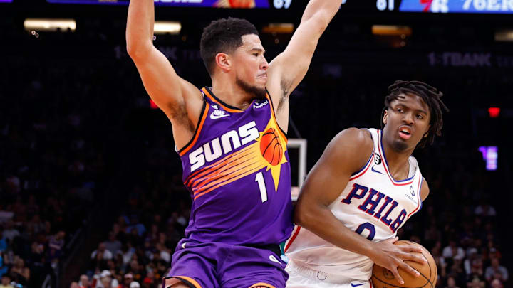 Mar 25, 2023; Phoenix, Arizona, USA; Philadelphia 76ers guard Tyrese Maxey (0) drives against Phoenix Suns guard Devin Booker (1) during the game at Footprint Center. Mandatory Credit: Chris Coduto-Imagn Images