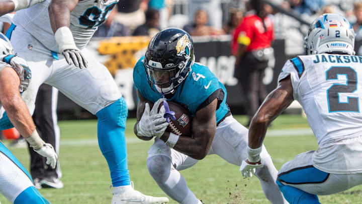 Jacksonville Jaguars running back Tank Bigsby (4) eludes Carolina Panthers defensive end Derrick Brown (95) an d Carolina Panthers cornerback Mike Jackson (2) during the fourth quarter of an NFL football game between the Carolina Panthers at Jacksonville Jaguars at EverBank Stadium Sunday September 7, 2025. Jaguars defeated the Panthers 26-10. [Doug Engle/Florida Times-Union]
