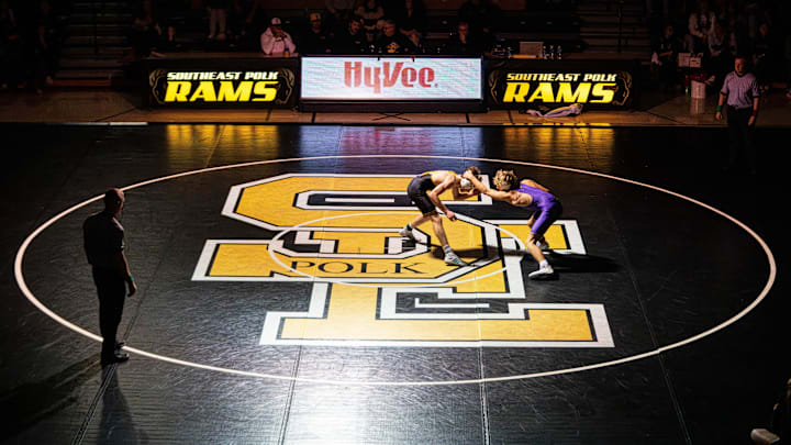 Southeast Polks Nash Hanson and Johnston’s Ike Beirman wrestle during a meet on Dec. 4, 2025, at Southeast Polk High School.