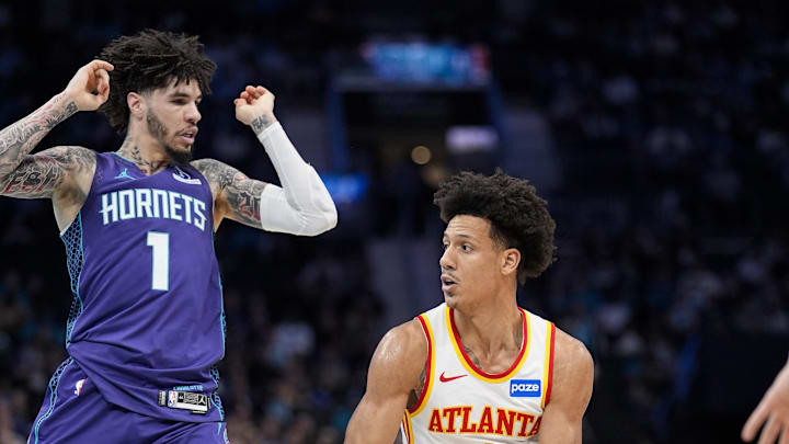 Feb 11, 2026; Charlotte, North Carolina, USA; Atlanta Hawks forward Jalen Johnson (1) looks to pass the ball defended by Charlotte Hornets guard LaMelo Ball (1) during first quarter at Spectrum Center. Mandatory Credit: Jim Dedmon-Imagn Images