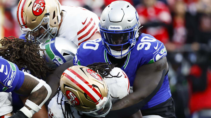 Oct 10, 2024; Seattle, Washington, USA; Seattle Seahawks defensive tackle Jarran Reed (90) tackles San Francisco 49ers running back Jordan Mason (24) during the first quarter at Lumen Field. Mandatory Credit: Joe Nicholson-Imagn Images