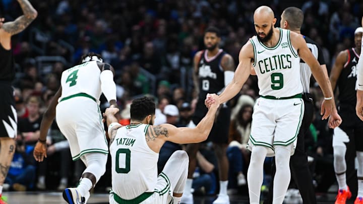 Dec 23, 2023; Los Angeles, California, USA; Boston Celtics guard Derrick White (9) and guard Jrue Holiday (4) help teammate forward Jayson Tatum (0) off the floor against the Los Angeles Clippers during the third quarter at Crypto.com Arena. Mandatory Credit: Jonathan Hui-Imagn Images