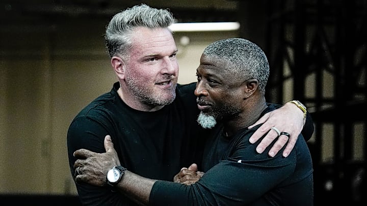 Pat McAfee hugs Detroit Lions defensive coordinator Aaron Glenn before the game between Indianapolis Colts and Detroit Lions at Lucas Oil Stadium on Sunday, Nov. 24, 2024.