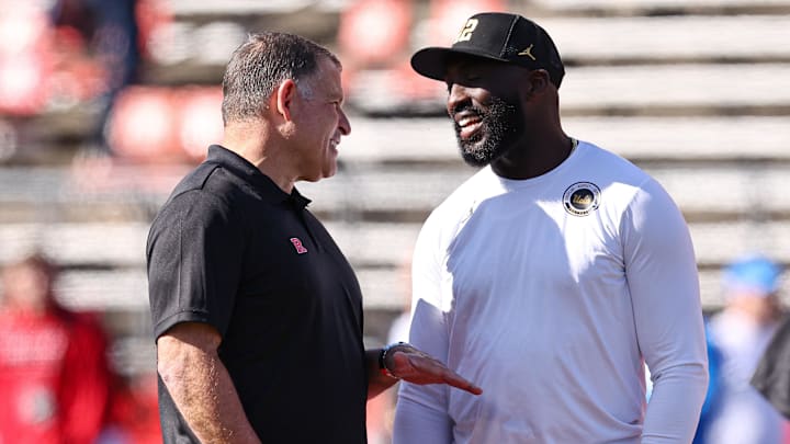 Oct 19, 2024; Piscataway, New Jersey, USA; Rutgers Scarlet Knights head coach Greg Schiano, left, talks with UCLA Bruins head coach DeShaun Foster before their Big Ten conference game at SHI Stadium. Mandatory Credit: Vincent Carchietta-Imagn Images