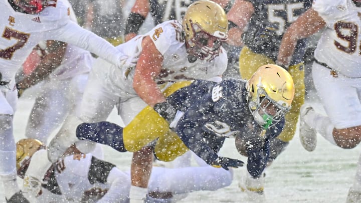 Nov 19, 2022; South Bend, Indiana, USA; Notre Dame Fighting Irish running back Chris Tyree (25) is tackled by Boston College Eagles linebacker Vinny DePalma (42) in the third quarter at Notre Dame Stadium. 