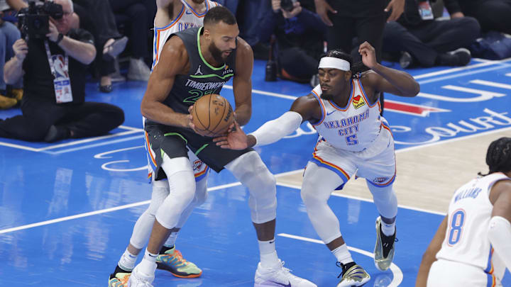 May 20, 2025; Oklahoma City, Oklahoma, USA; Minnesota Timberwolves center Rudy Gobert (27) and Oklahoma City Thunder guard Luguentz Dort (5) fight for a rebound during the first quarter in game one of the western conference finals for the 2025 NBA Playoffs at Paycom Center. Mandatory Credit: Alonzo Adams-Imagn Images