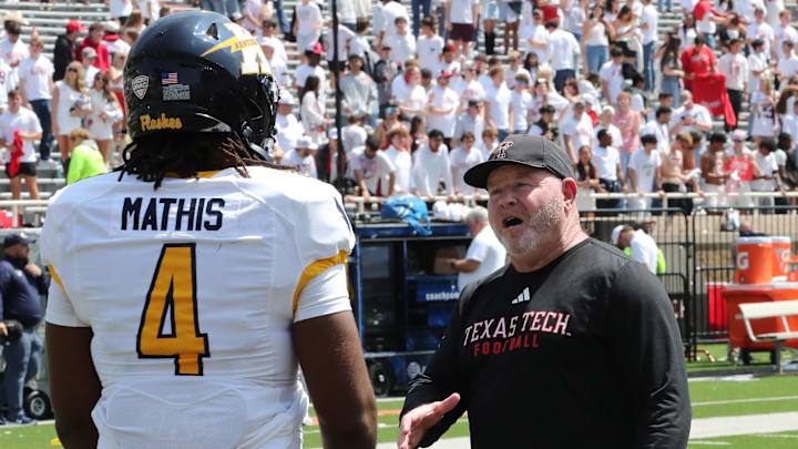Texas Tech Red Raiders associate head coach Kenny Perry visits with Kent State Golden Flashes defensive end Jamond Mathis (4) after the game at Jones AT&T Stadium. 