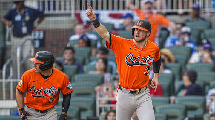 Jul 5, 2025; Cumberland, Georgia, USA; Baltimore Orioles first baseman Ryan O'Hearn (32) and right fielder Ramon Laureano (rear left) react after scoring against the Atlanta Braves during the tenth inning at Truist Park. Mandatory Credit: Dale Zanine-Imagn Images