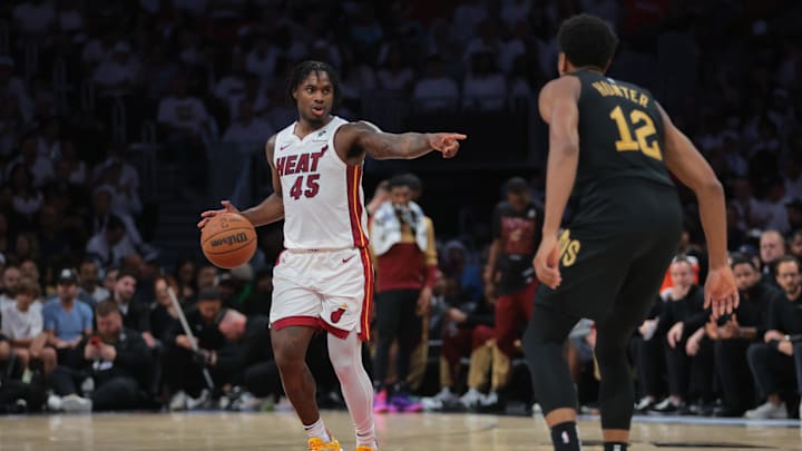 Apr 26, 2025; Miami, Florida, USA; Miami Heat guard Davion Mitchell (45) signals as Cleveland Cavaliers forward De'Andre Hunter (12) defends in the third quarter during game three for the first round of the 2025 NBA Playoffs at Kaseya Center. Mandatory Credit: Sam Navarro-Imagn Images