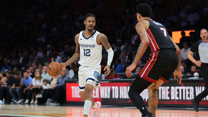 Apr 3, 2025; Miami, Florida, USA; Memphis Grizzlies guard Ja Morant (12) dribbles the basketball as Miami Heat center Kel'el Ware (7) defends during the first quarter at Kaseya Center. Mandatory Credit: Sam Navarro-Imagn Images
