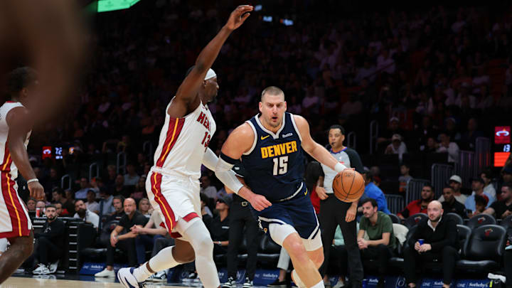 Dec 29, 2025; Miami, Florida, USA; Denver Nuggets center Nikola Jokic (15) drives to the basket against Miami Heat center Bam Adebayo (13) during the first quarter at Kaseya Center. Mandatory Credit: Sam Navarro-Imagn Images