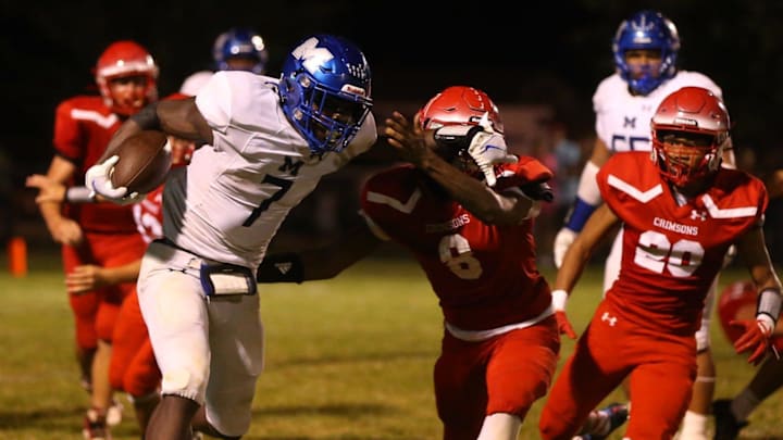 Decatur MacArthur's Myson Johnson-Cook stiff arms a Jacksonville defender during a Central State Eight Conference football game at Kraushaar-Rosenberger Field on Friday, Sept. 1, 2023.