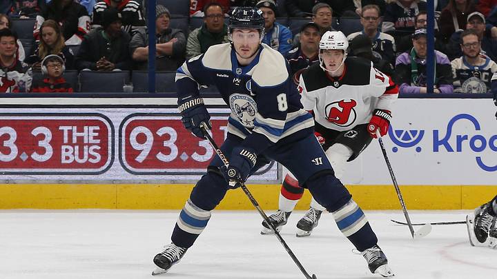 Mar 17, 2025; Columbus, Ohio, USA; Columbus Blue Jackets defenseman Zach Werenski (8) looks to pass as New Jersey Devils center Cody Glass (12) trails the play during the third period at Nationwide Arena. Mandatory Credit: Russell LaBounty-Imagn Images