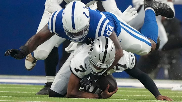 Oct 5, 2025; Indianapolis, Indiana, USA; Indianapolis Colts defensive end Tyquan Lewis (94) brings down Las Vegas Raiders quarterback Geno Smith (7) during a game at Lucas Oil Stadium. Mandatory Credit: Christine Tannous-USA TODAY Network via Imagn Images