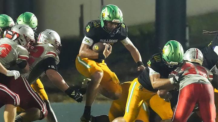 DeLand's Gardner Nordman (4) jumps through a hole and gets a first down during a game against Lake Mary on Sept. 11, 2026 in DeLand. The Bulldogs went on to win, 33-0. DeLand's Gardner Nordman (4) jumps through a hole and gets a first down during a game against Lake Mary on Sept. 11, 2026 in DeLand. The Bulldogs went on to win, 33-0.