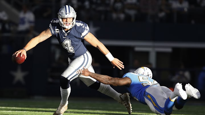 Dallas Cowboys quarterback Dak Prescott avoids a tackle by Los Angeles Chargers linebacker Melvin Ingram at AT&T Stadium. 