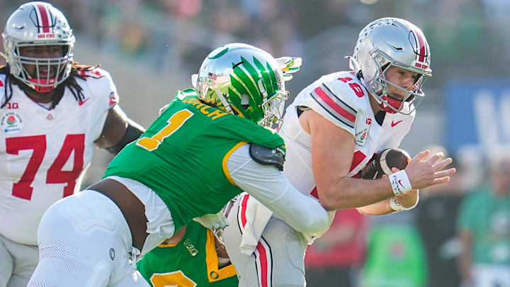 Ohio State Buckeyes quarterback Will Howard (18) runs through Oregon Ducks defensive end Jordan Burch (1) during the first half of the College Football Playoff quarterfinal at the Rose Bowl in Pasadena, Calif. on Jan. 1, 2025. Ohio State Buckeyes quarterback Will Howard (18) runs through Oregon Ducks defensive end Jordan Burch (1) during the first half of the College Football Playoff quarterfinal at the Rose Bowl in Pasadena, Calif. on Jan. 1, 2025.