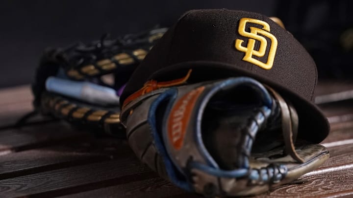 Jul 23, 2021; Miami, Florida, USA; A general view of a San Diego Padres hat and glove in the dugout prior to the game between the Miami Marlins and the San Diego Padres at loanDepot park. Mandatory Credit: Jasen Vinlove-Imagn Images Jul 23, 2021; Miami, Florida, USA; A general view of a San Diego Padres hat and glove in the dugout prior to the game between the Miami Marlins and the San Diego Padres at loanDepot park. Mandatory Credit: Jasen Vinlove-Imagn Images