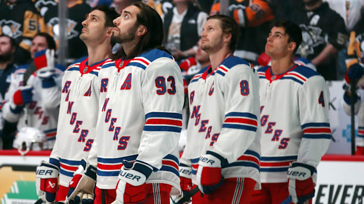 Oct 9, 2024; Pittsburgh, Pennsylvania, USA;   New York Rangers players left wing Chris Kreider (left) and center Mika Zibanejad (93) defensemen Jacob Trouba (8) and Braden Schneider (4) watch a video tribute to the late Columbus Blue Jackets left wing Johnny Gaudreau (not pictured) before the game against the Pittsburgh Penguins at PPG Paints Arena. Mandatory Credit: Charles LeClaire-Imagn Images